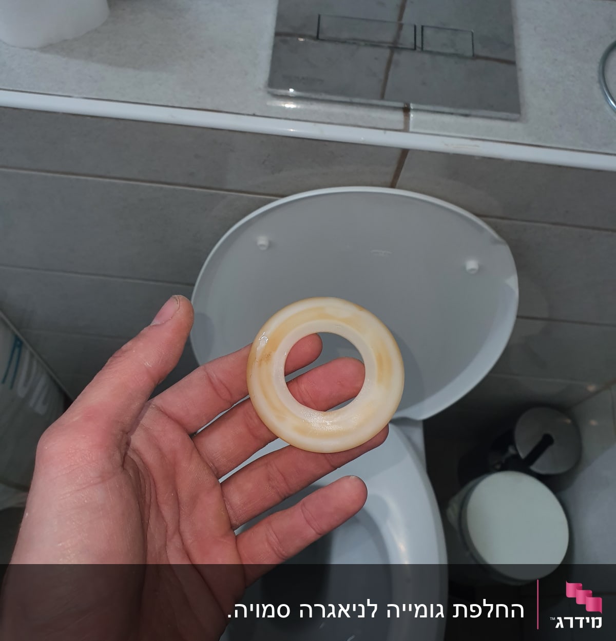 יד מחזיקה טבעת פלסטיק ליד אסלה בשירותים